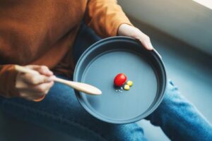 person eating vegetables in an eating disorder treatment program