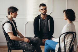 three people in chairs in a self-injury treatment program