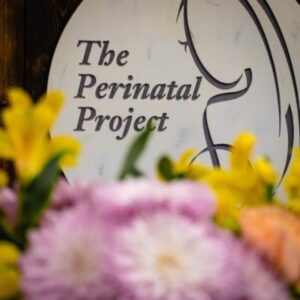 sign for the perinatal project next to flowers