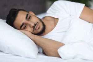 man laying on pillow considers treatment for sleep problems