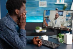 man looking at screen for a telehealth mental health appointment