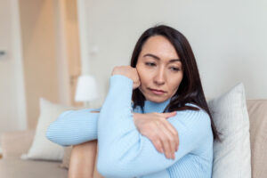 woman in blue sweater experiences signs of anxiety
