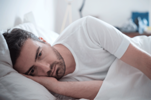 man lays in bed and wonders about the major types of depression