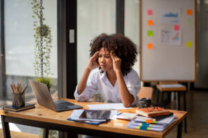 woman with head in hands considers stress management techniques