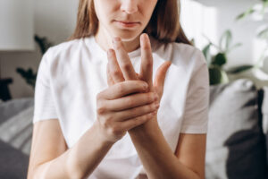 woman holding her hand considers the signs of self-injurious behavior