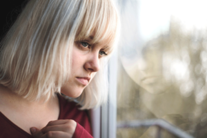 woman looking out of the window considers the myths about bipolar disorder