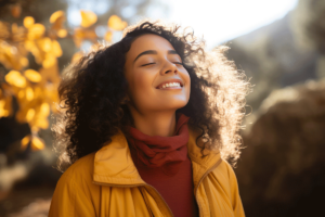 woman smiles outdoors while thinking about mental health goals