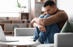 man holds legs and learns about types of psychotic disorders