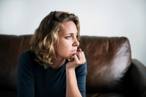woman on couch thinks about depression and isolation