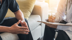 person sitting on couch talks to therapist about tms treatment for depression