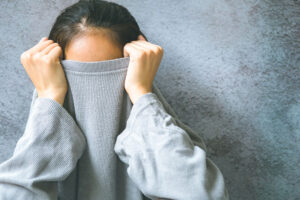 woman pulling sweatshirt over head wonders if she has social anxiety