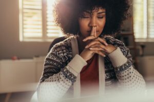 young woman seated in a meditative pose practicing helpful tips for reducing anxiety