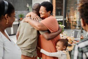 family hugs each other on outdoor patio