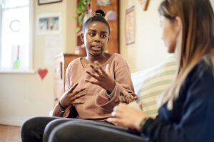 A young woman speaks to her therapist. She is participating in trauma therapy in Towson, MD.
