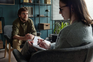 man talks with therapist about social anxiety triggers and how to manage them