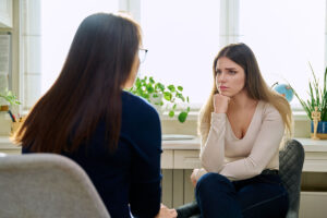 woman talks with therapist about signs and symptoms of bipolar disorder she's experiencing